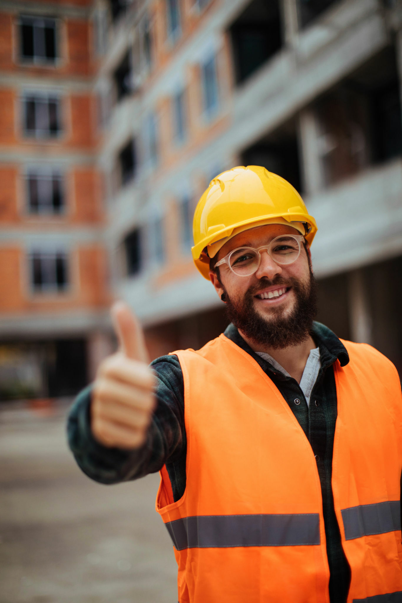 Portrait shot of a smiling young construction worker standing in a building site